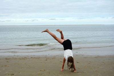 Full length of woman on beach against sky