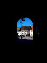 Silhouette buildings against sky seen through window