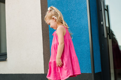 Young woman standing against wall