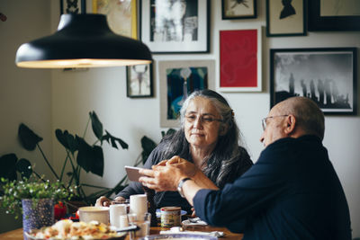 Senior couple using mobile phone at table