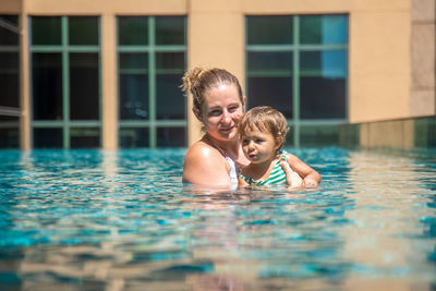 Mother and daughter swimming in pool