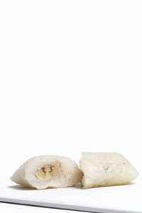 Close-up of bread in plate against white background