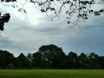 Scenic view of grassy field against cloudy sky