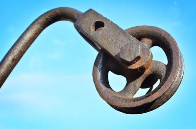 Low angle view of rusty metal against sky