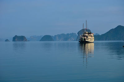 Boat sailing in river against clear sky