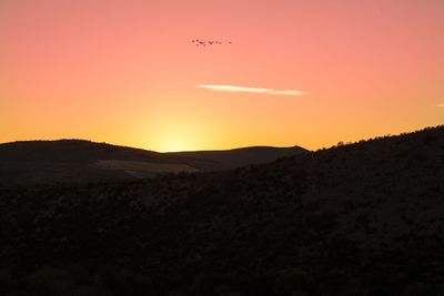 Scenic view of silhouette mountains against sky during sunset