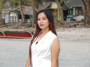 Portrait of young woman standing at beach