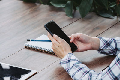 High angle view of man using mobile phone on table