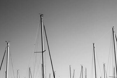 Masts at harbor against clear sky