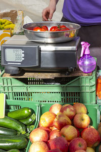 Midsection of person preparing fruits in container at kitchen