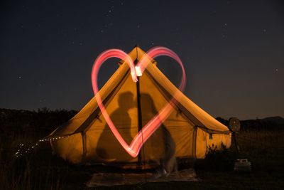 Light trails on field against sky at night