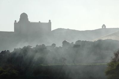 Scenic view of tomb in dust against sky