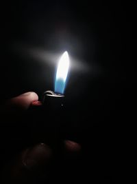 Cropped image of hand holding illuminated lamp