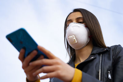 Woman with a doctor mask using the phone. virus protection.