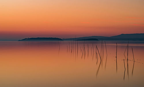 Scenic view of lake against romantic sky at sunset