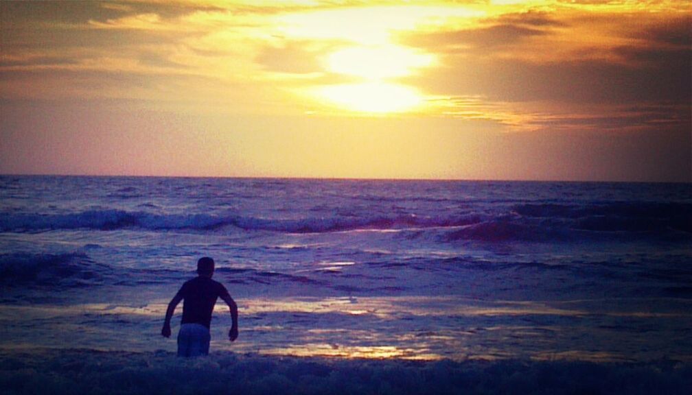 sea, horizon over water, beach, water, sunset, shore, leisure activity, scenics, sky, beauty in nature, lifestyles, wave, tranquil scene, silhouette, standing, tranquility, men, idyllic