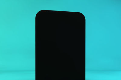 Close-up of smart phone against blue background