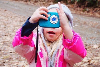 Close-up of woman holding pink camera