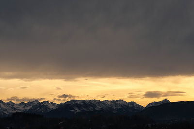 Scenic view of snowcapped mountains against sky at sunset