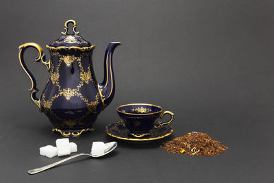 Close-up of tea cup on table against black background