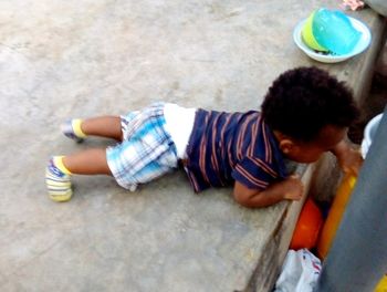 High angle view of boy lying on couch