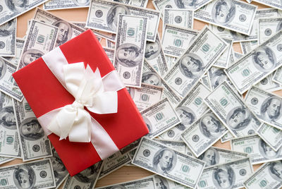 High angle view of gift box with paper currencies on table