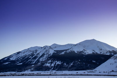 Scenic view of snowcapped mountains against clear blue sky