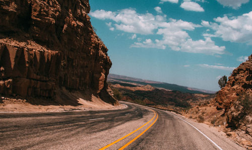 Road passing through landscape against sky
