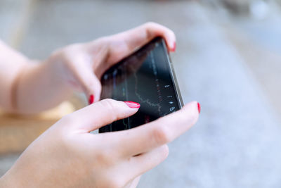 Midsection of person holding camera against blurred background