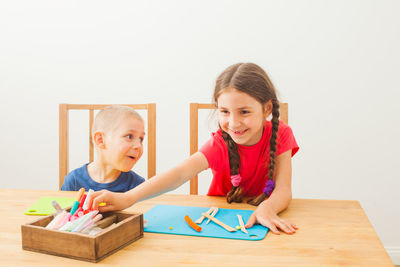 Portrait of a smiling girl with toy on table