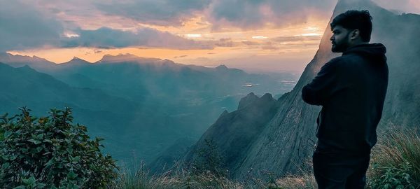 Midsection of man standing on mountain against sky