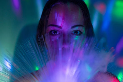 Close-up portrait of young woman with fiber optic