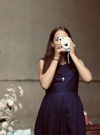 Portrait of woman sitting against wall at home