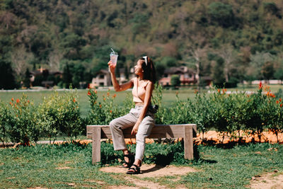 Side view of woman sitting on bench