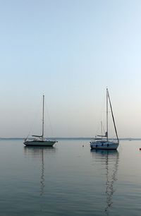 Sailboat sailing on lake against clear sky