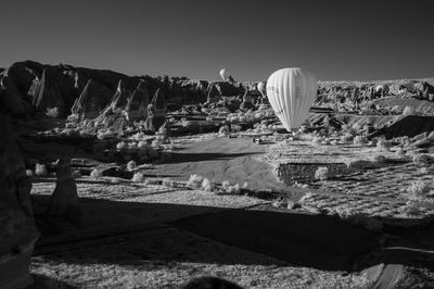 Hot air balloons over landscape at cappadocia against clear sky