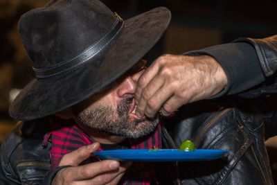 Close-up portrait of man holding hat