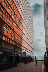 Man walking by modern buildings in city