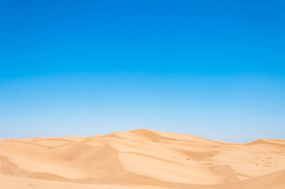 Scenic view of desert against clear blue sky