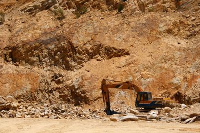 Earth mover against rock formation