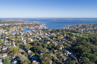 High angle view of town by sea against clear sky