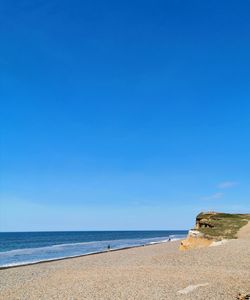 Scenic view of big blue sky with cliff and sea and shoreline 