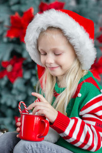 Cute little child girl eating sweet cookies and drinking hot chocolate