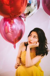 Portrait of young woman with balloons