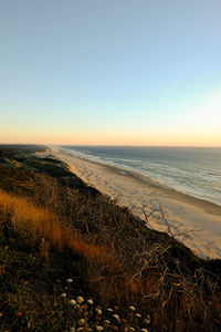 Scenic view of sea against clear sky during sunset