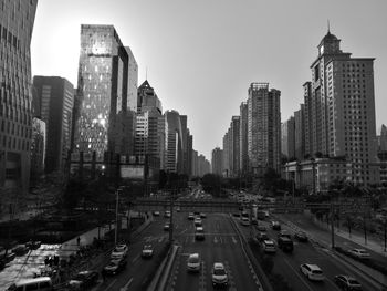 Vehicles on road in city against sky