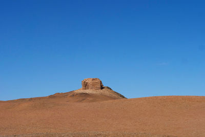 Stone wall on desert against clear blue sky