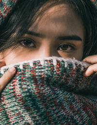 Close-up portrait of young woman covering face