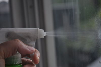 Close-up of person spraying disinfectant
