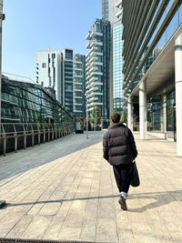 Rear view of man walking on street in city